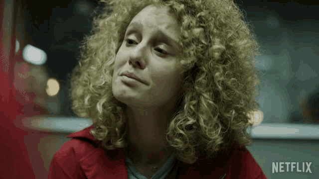 a close up of a woman with curly hair and a netflix logo behind her