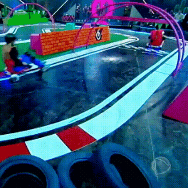 a race track with a red white and blue stripe and a brick wall with the letter o on it