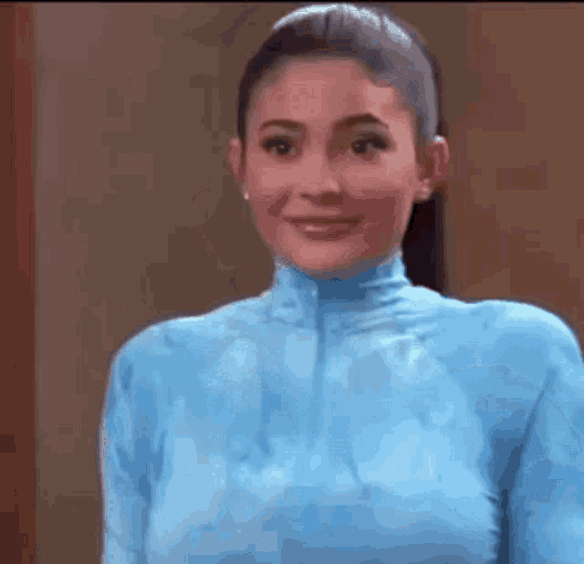 a woman is wearing a blue top and smiling .
