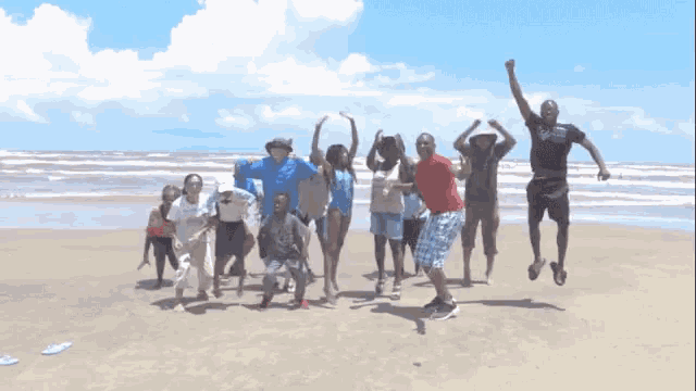 a group of people jump in the air on a beach