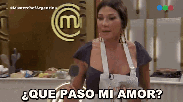 a woman is standing in front of a masterchef logo