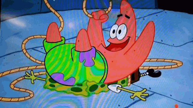 patrick star from spongebob squarepants is laying on the ground with a rope around his waist .