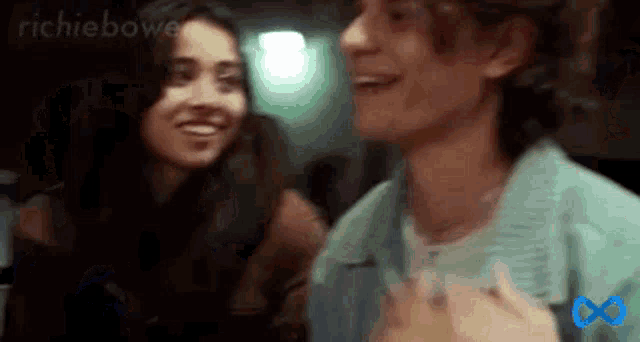 a man and a woman are laughing together in a dark room .