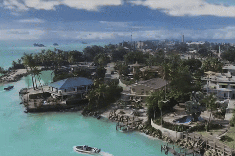 an aerial view of a tropical island with a boat in the foreground
