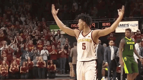 a basketball player with the number 5 on his jersey stands on the court