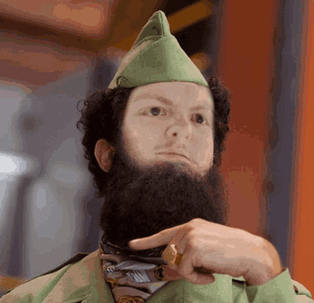 a man with a beard is wearing a green hat and a gold ring