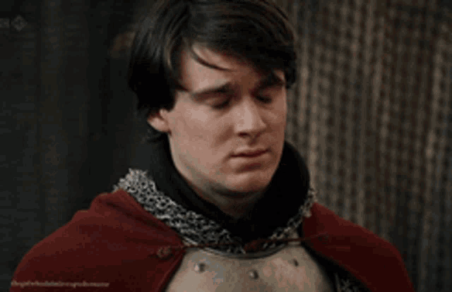 a man in armor with a red cape on his head