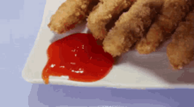 a plate of chicken nuggets and ketchup on a table