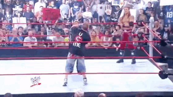 a man is standing in a wrestling ring with a sign that says `` i love you '' .