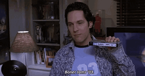 a man in a blue shirt with the number 03 on it is holding a tape that says boner jams 03