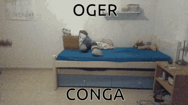 a bed with a blue blanket and the words oger conga on the bottom