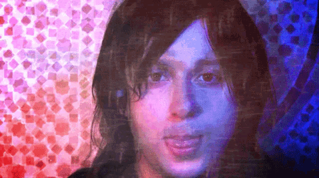 a close up of a person 's face with a blue and red background