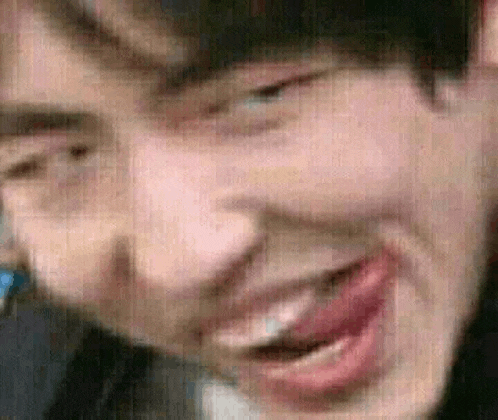 a close up of a man 's face with his tongue hanging out .