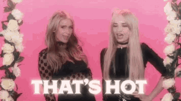 two women are standing next to each other in front of a pink background and the words `` that 's hot '' .