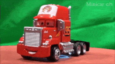 a toy truck from the movie cars is sitting on a table with a green background .