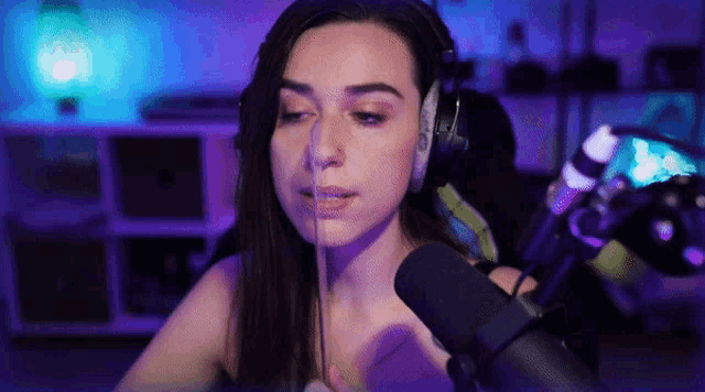 a woman is wearing headphones and talking into a microphone ..