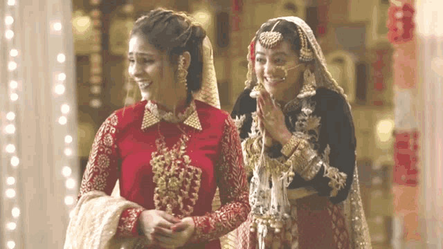 a bride and a bridesmaid are standing next to each other