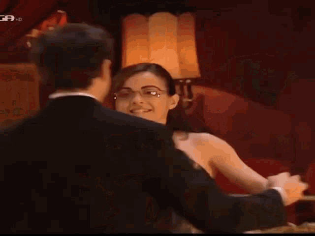 a man in a suit is touching a woman 's hair with a gf hd logo on the bottom