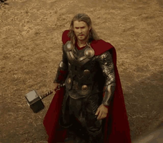 a man in armor is holding a hammer in his hand .