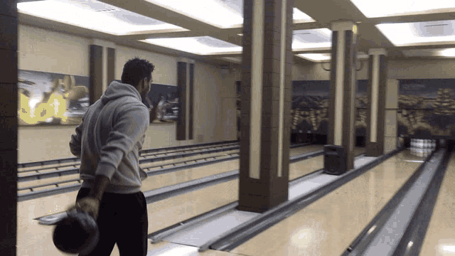 a man throws a bowling ball in a bowling alley