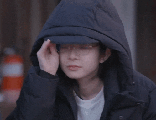 a person wearing a hat and a hooded jacket