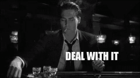 a man in a suit and tie is smoking a cigarette in a bar .