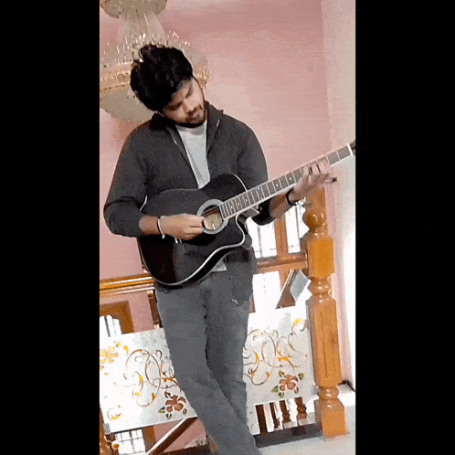 a man playing an acoustic guitar in a room