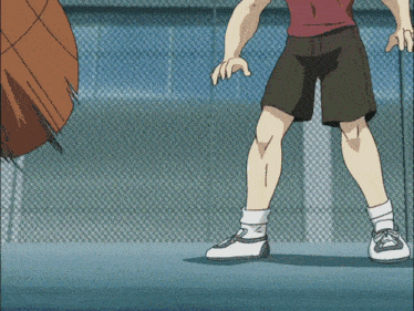 a person wearing a red shirt and black shorts stands in front of a fence