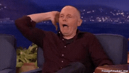 a man is sitting on a couch with his arms in the air .