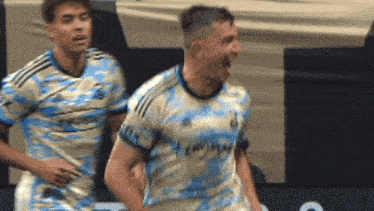 two soccer players are celebrating a goal with their mouths open