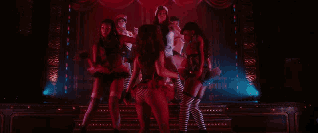 a group of women are dancing on a stage and one of them is wearing striped socks