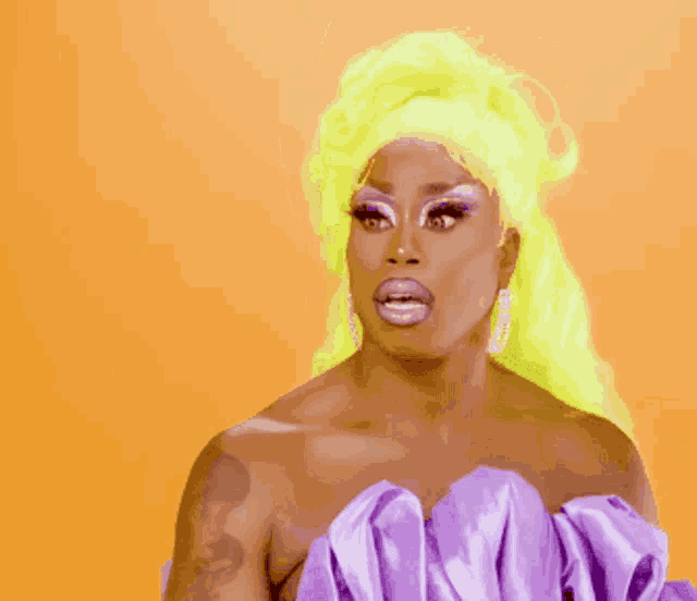 a drag queen with yellow hair is wearing a purple top
