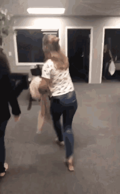 a woman is holding a dog in her arms while another woman looks on