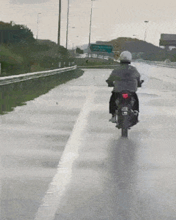 a person is riding a motorcycle on a highway with a license plate that says jz8