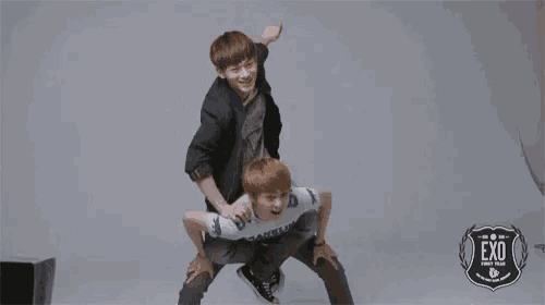 a man is carrying another man on his back with a sign that says exo on it