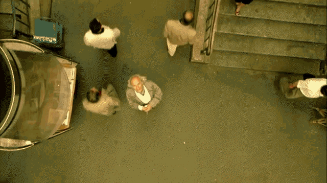 an aerial view of a woman laying on the floor in front of a staircase and a fireball