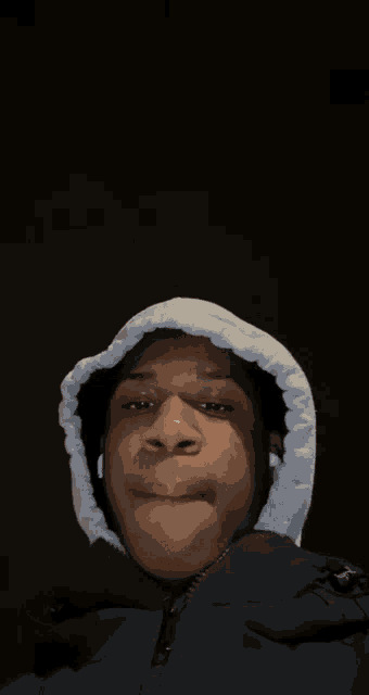 a young man wearing a black jacket and a white hood