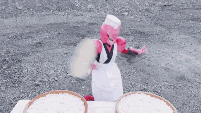 a robot in a chef 's apron is standing in front of two bowls of rice