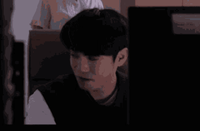 a man is smiling while sitting in front of a computer screen