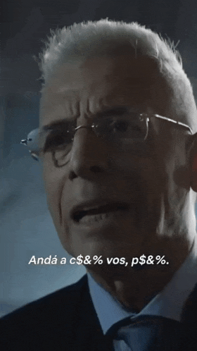 a man wearing glasses and a suit says " andá a c $ & % vos p $ & % "