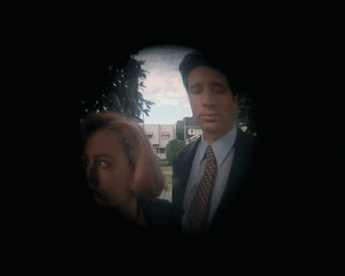 a man and a woman are standing next to each other in a dark room