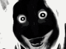 a black and white photo of a dog with big eyes and a scary face .