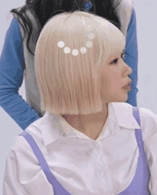 a woman with blonde hair is wearing a white shirt and purple straps