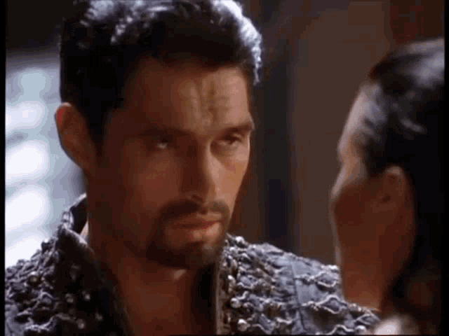 a man with a beard and a woman are looking at each other in a room .