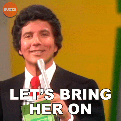 a man is holding a microphone and says let 's bring her on
