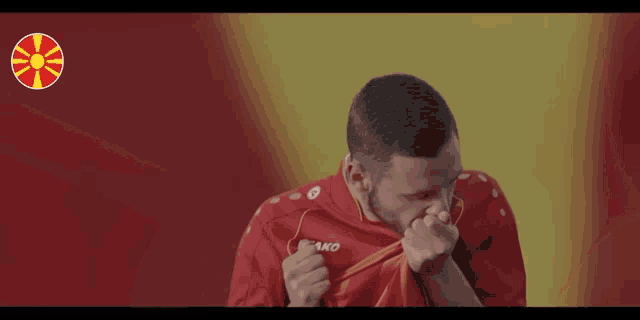 a man with a beard wearing a red jersey with jako on the front