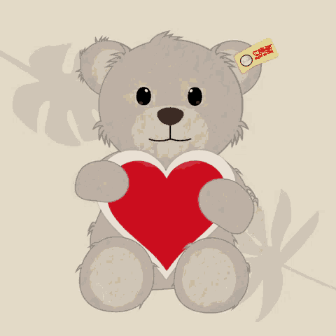 a steiff teddy bear is holding a heart