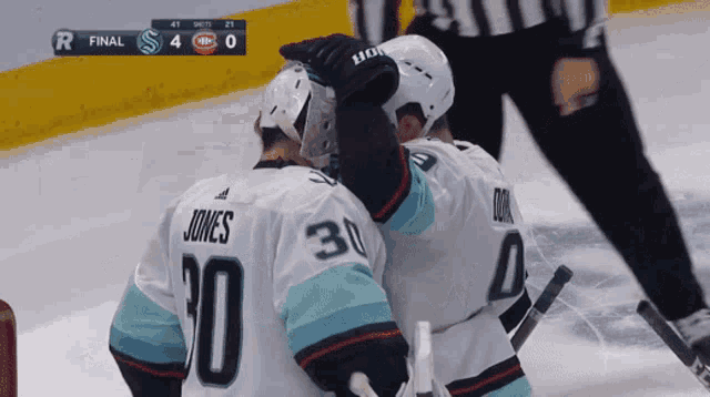 a hockey player named jones is hugging another player on the ice