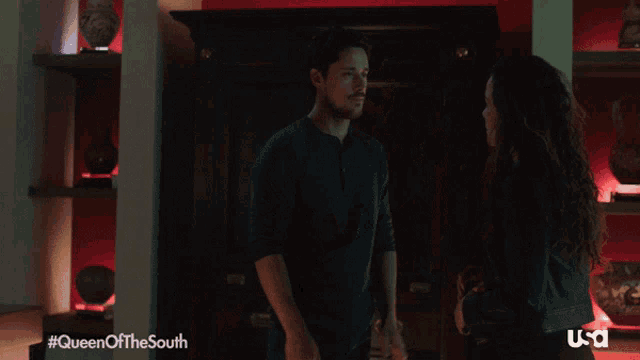 a man and a woman are hugging in a room with the hashtag queen of the south on the bottom