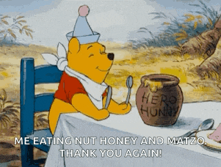 winnie the pooh is sitting at a table with a pot of honey